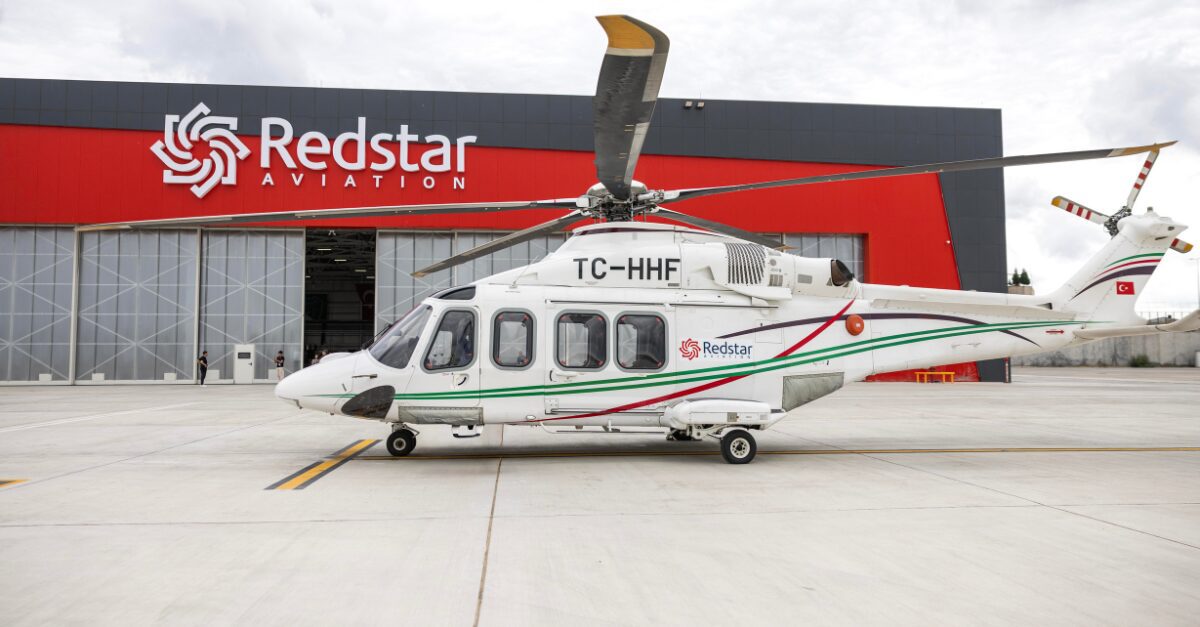 Redstar Aviation helicopter in front of a company-branded building