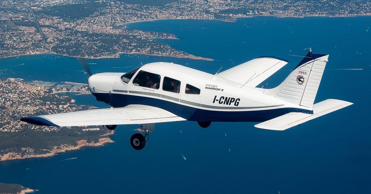 Aero Club Torino aircraft flying over a body of water