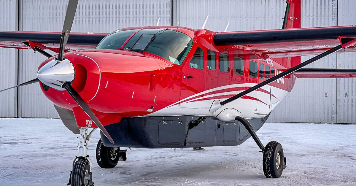A red and white Grant Aviation airplane parked in a hangar