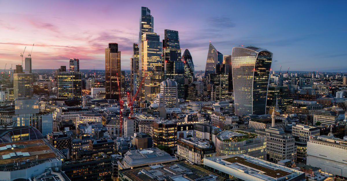 Aerial view of the illuminated skyscrapers at the City of London, England, during evening time with a colourful sky